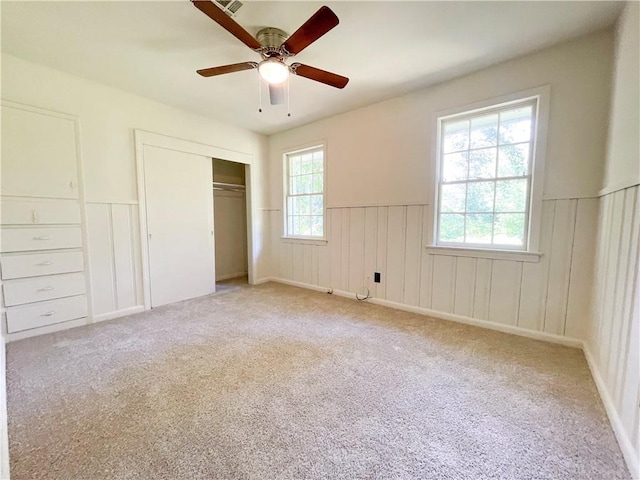 108 N Dr, Covington, LA 70433 - unfurnished bedroom with wainscoting, light carpet, a closet, and a ceiling fan