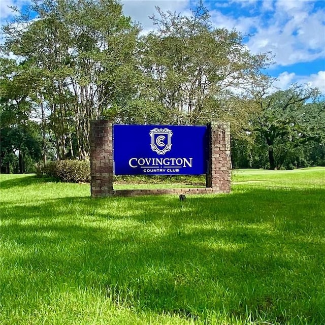 community / neighborhood sign featuring a lawn