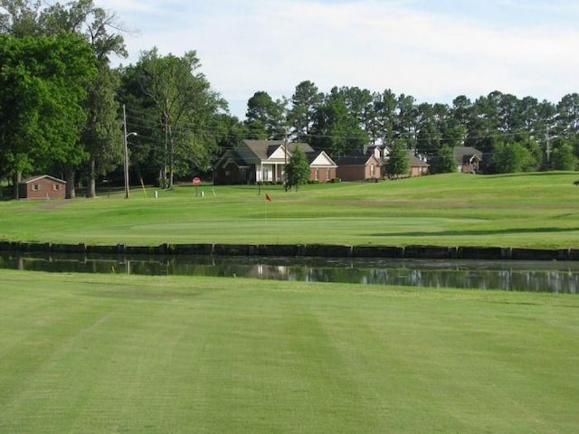 view of property's community with a water view and a yard