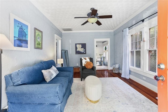 living room featuring crown molding, ceiling fan, and dark wood-type flooring