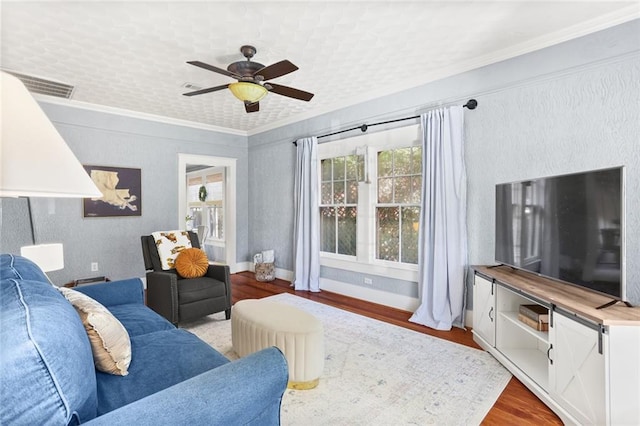 living room with light hardwood / wood-style floors, ceiling fan, and ornamental molding