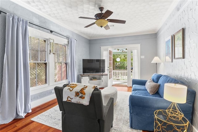 living room featuring hardwood / wood-style flooring, ceiling fan, and crown molding