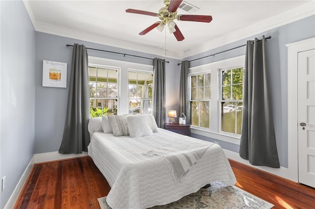 bedroom with dark hardwood / wood-style floors, multiple windows, and ceiling fan