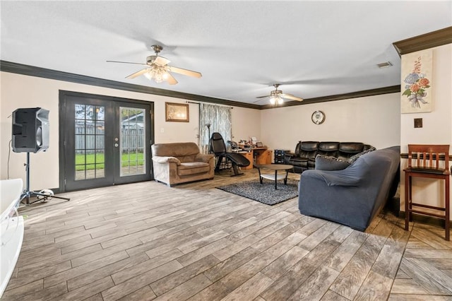 living room with ceiling fan, light hardwood / wood-style floors, ornamental molding, and french doors