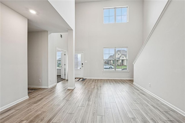 foyer featuring a towering ceiling and light hardwood / wood-style floors