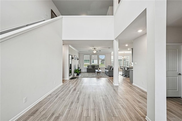 entrance foyer featuring ceiling fan with notable chandelier and light hardwood / wood-style flooring