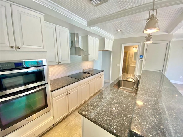 kitchen featuring a sink, backsplash, stainless steel double oven, wall chimney exhaust hood, and black electric cooktop