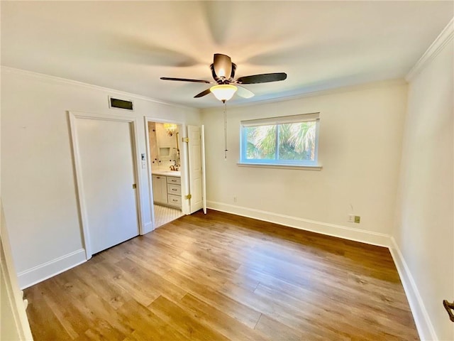 unfurnished bedroom featuring light wood-type flooring, baseboards, and ornamental molding