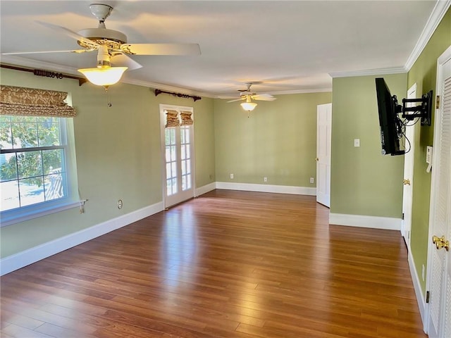 spare room featuring a healthy amount of sunlight, crown molding, and wood finished floors