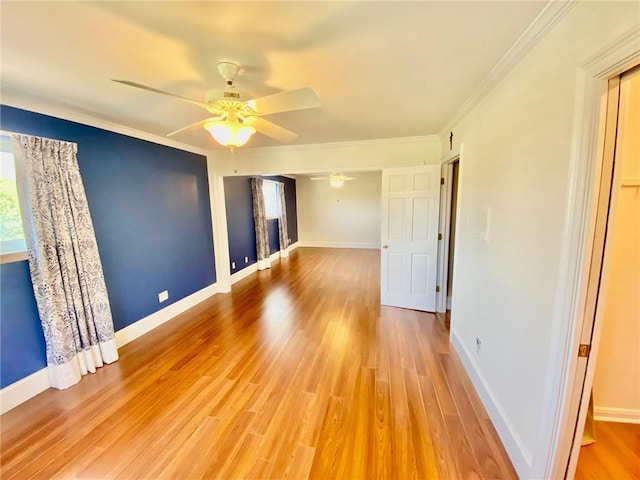 unfurnished room with baseboards, ornamental molding, a ceiling fan, and light wood finished floors