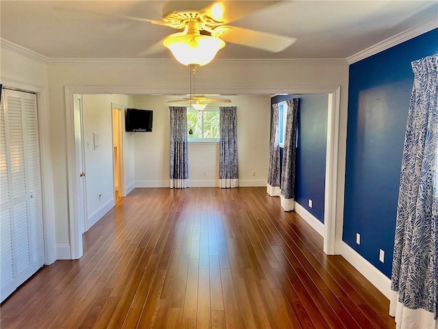 interior space featuring ceiling fan, baseboards, wood finished floors, and crown molding