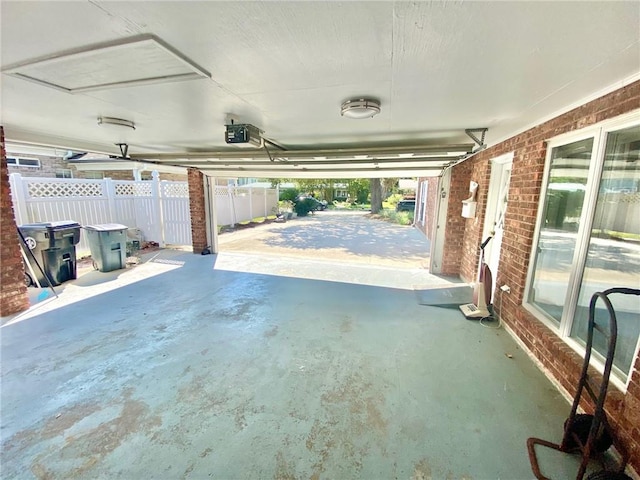 garage featuring a garage door opener and fence