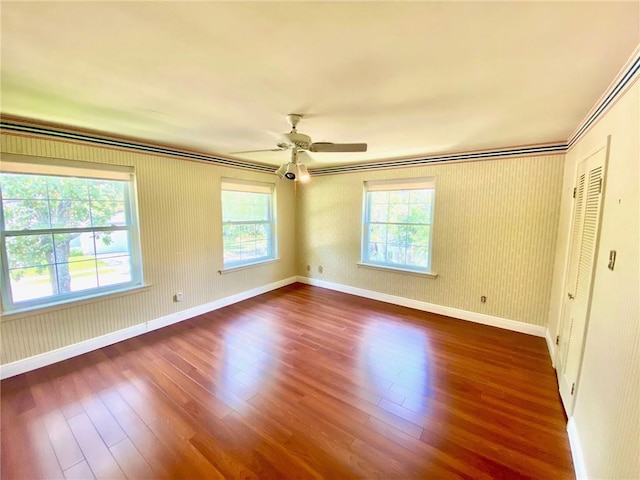 unfurnished bedroom with dark wood-style floors, a ceiling fan, and baseboards