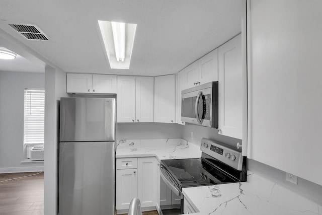 kitchen with white cabinets, light stone countertops, and appliances with stainless steel finishes