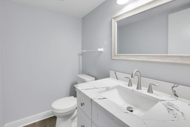 bathroom with vanity, hardwood / wood-style flooring, and toilet