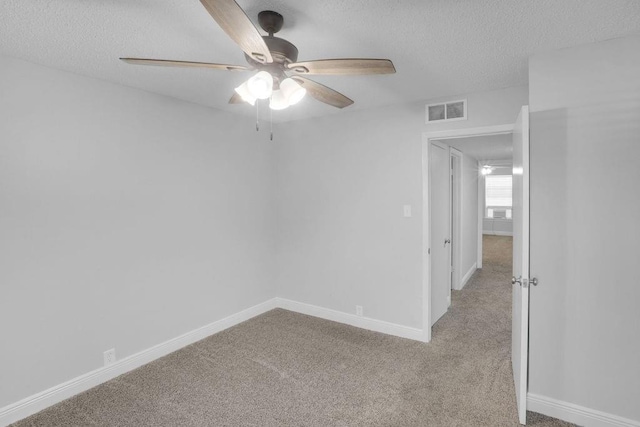 carpeted empty room with a textured ceiling and ceiling fan