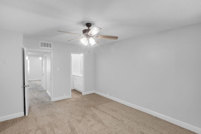 unfurnished bedroom with ceiling fan, light colored carpet, and a textured ceiling