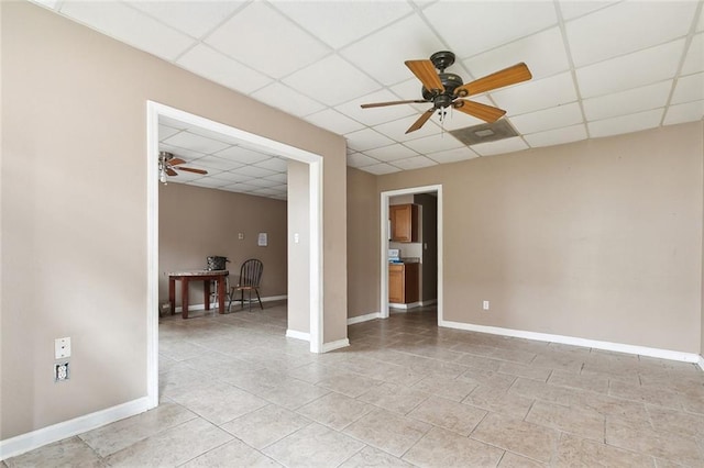 tiled spare room featuring a paneled ceiling and ceiling fan