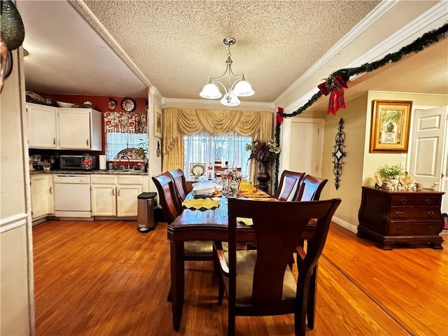 dining room with crown molding, hardwood / wood-style floors, a textured ceiling, and an inviting chandelier