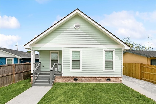 back of property with a yard and a porch