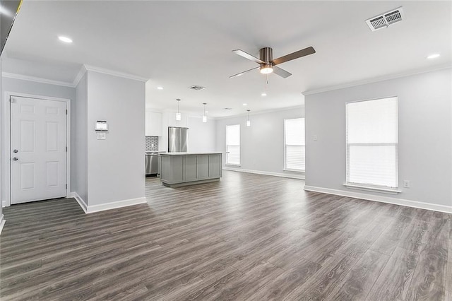 unfurnished living room with ceiling fan, dark wood-type flooring, and ornamental molding