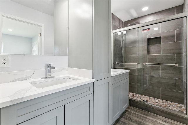 bathroom featuring wood-type flooring, vanity, and an enclosed shower