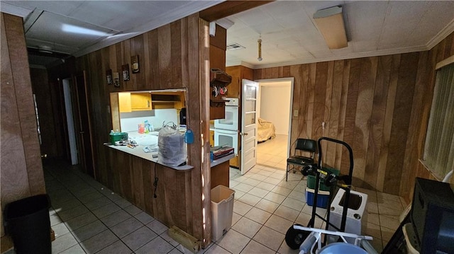 kitchen with double oven, ornamental molding, and wooden walls