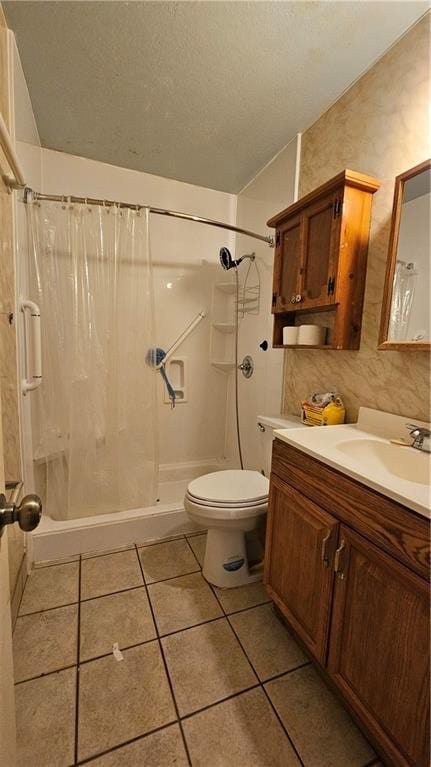 bathroom with toilet, vanity, tile patterned floors, and curtained shower