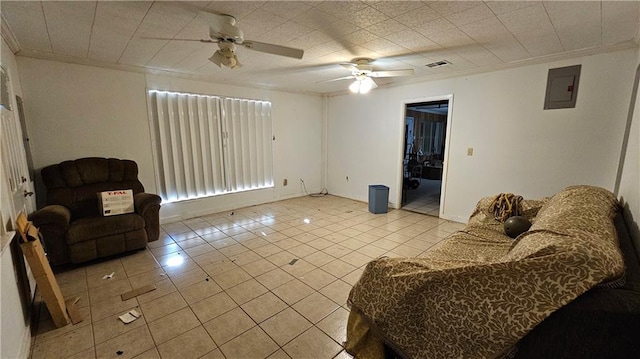 living room featuring electric panel, crown molding, light tile patterned flooring, and ceiling fan