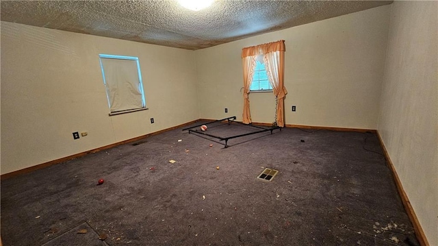 unfurnished room featuring carpet and a textured ceiling