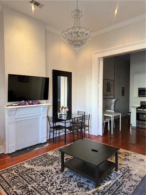 living room with dark hardwood / wood-style flooring, crown molding, and an inviting chandelier