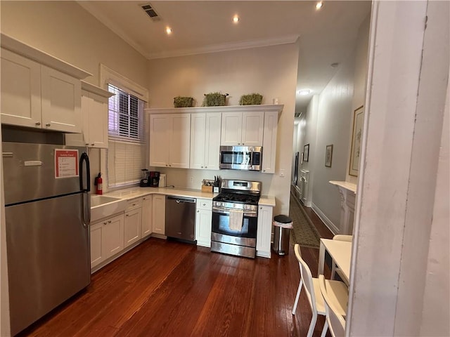 kitchen with white cabinetry, tasteful backsplash, dark hardwood / wood-style flooring, crown molding, and appliances with stainless steel finishes