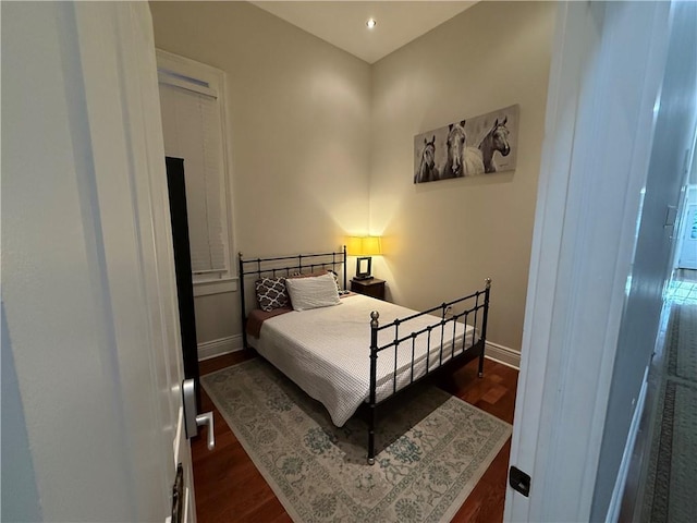 bedroom with dark hardwood / wood-style flooring