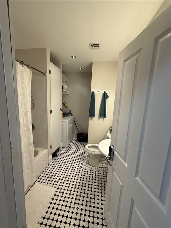 bathroom featuring toilet and shower / bath combo with shower curtain