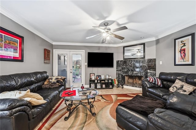 living room with ceiling fan, crown molding, a high end fireplace, and french doors