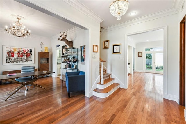 corridor with hardwood / wood-style floors, ornamental molding, french doors, and an inviting chandelier