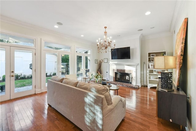 living room with french doors, a brick fireplace, ornamental molding, and dark wood-type flooring