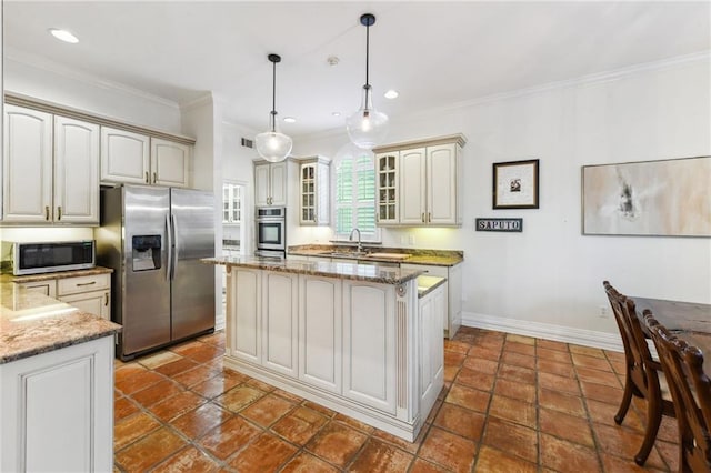 kitchen featuring stainless steel appliances, crown molding, stone counters, a center island, and hanging light fixtures