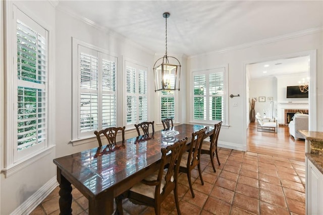 dining area with crown molding, a fireplace, and a notable chandelier