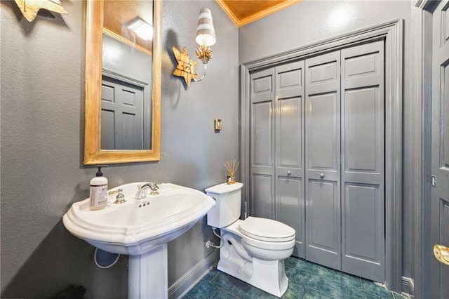 bathroom featuring tile patterned flooring, toilet, and crown molding