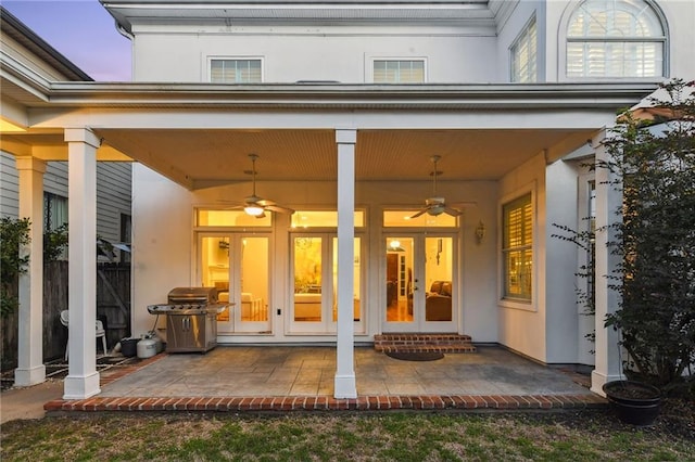 exterior entry at dusk featuring french doors and ceiling fan