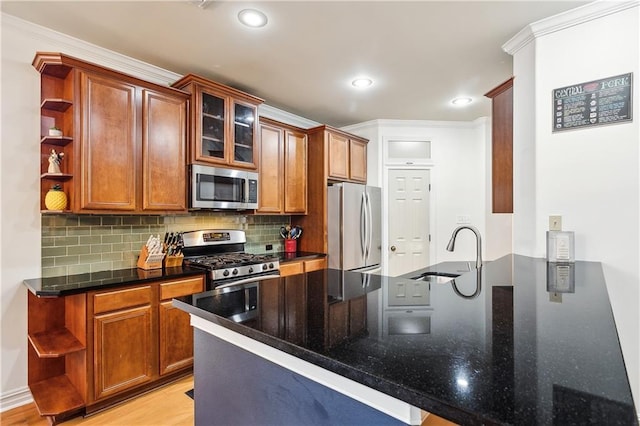 kitchen featuring sink, stainless steel appliances, kitchen peninsula, crown molding, and decorative backsplash