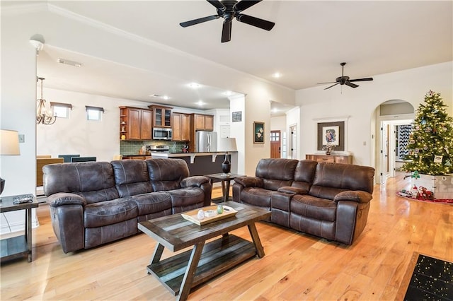 living room with light hardwood / wood-style flooring and ceiling fan with notable chandelier