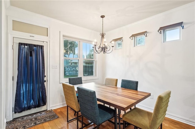 dining room with hardwood / wood-style flooring, plenty of natural light, and ornamental molding