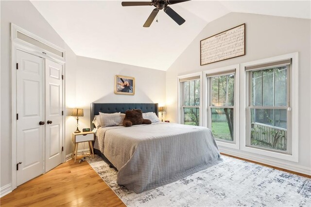 bedroom featuring hardwood / wood-style flooring, vaulted ceiling, and ceiling fan