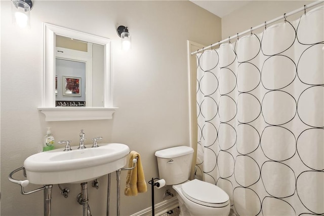 bathroom featuring curtained shower and toilet