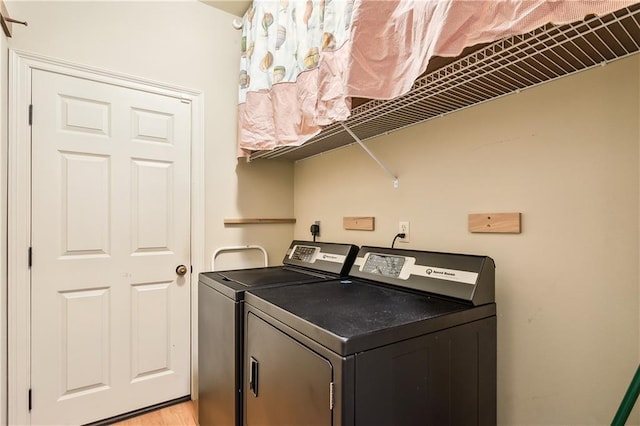 washroom with washing machine and clothes dryer and light wood-type flooring