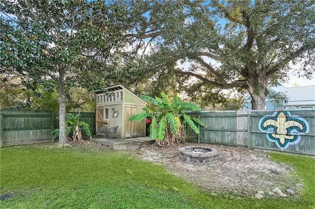 view of outbuilding featuring a lawn and an outdoor fire pit