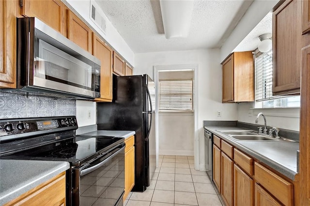 130 Village Dr Unit 130, Slidell, LA 70461 - kitchen featuring sink, decorative backsplash, a textured ceiling, appliances with stainless steel finishes, and light tile patterned flooring