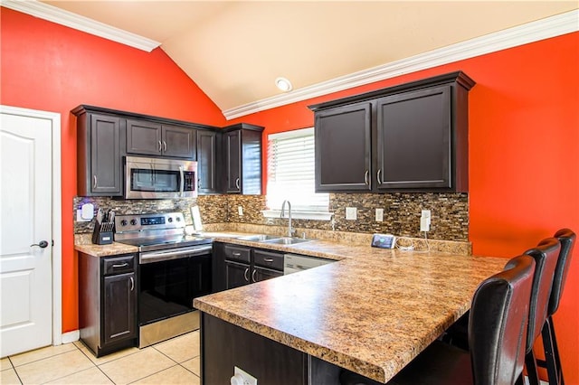 kitchen with kitchen peninsula, backsplash, stainless steel appliances, vaulted ceiling, and crown molding